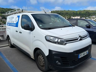 une camionnette blanche garée dans un parking à côté d'autres voitures
