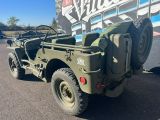 une jeep militaire garée devant un camion