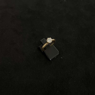 une image d'une bague en diamant sur une surface noire