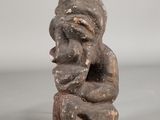 figurine of a seated man holding his hands to his face