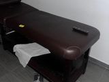 une table de massage recouverte d'une serviette, dans une pièce
