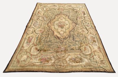 un tapis ancien orné d'un grand motif floral sur fond blanc