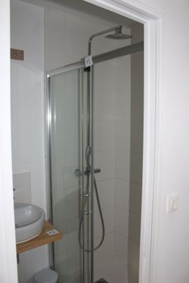 a shower with a glass door in a small bathroom