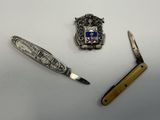 a knife, a pocket knife, and a pocket knife on a table