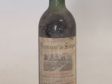 an old bottle of wine sitting on top of a white table