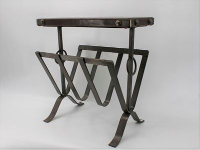 a metal table with a magazine rack on top of it