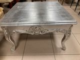 une table basse argentée posée sur un sol carrelé dans une pièce