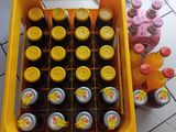 many bottles of beer in a yellow crate on the floor