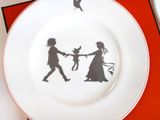 a plate with a picture of a couple and a bird on it