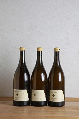 trois bouteilles de vin sont alignées sur une table en bois