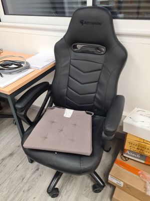 une chaise de bureau noire sur laquelle est posé un ordinateur portable