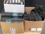 de nombreux rouleaux de tissu noir dans des cartons posés sur une palette