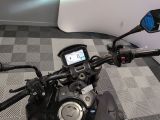a motorcycle that is sitting on the floor with a cell phone in the handlebar