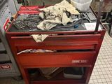 une boîte à outils rouge remplie d'outils, posée sur un sol carrelé