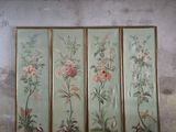 three framed paintings of flowers on a wall in a room