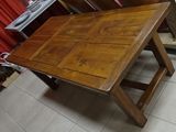 a wooden table that is sitting on a tile floor