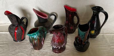 five different colored vases sitting on a table