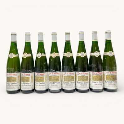 six bouteilles de vin sont alignées sur une surface blanche