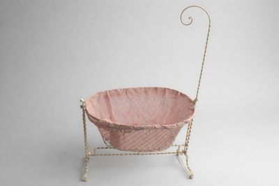 Berceau en métal laqué blanc à décor de croisillons.