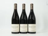 trois bouteilles de vin rouge sont posées sur une surface blanche