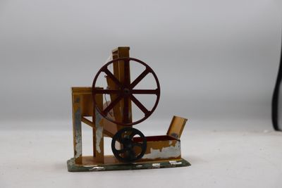une petite maquette de machine à filer posée sur une surface blanche