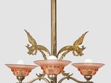 un lustre ancien en laiton avec des abat-jours en verre rose