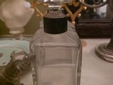 un flacon de parfum posé sur une table à côté d'une statue représentant un chat