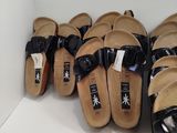many pairs of sandals lined up on a shelf