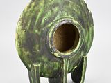 un vase vert qui a un trou au milieu
