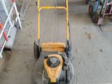 a yellow lawn mower that is sitting in a garage