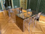 une table en verre avec des chaises et un miroir posé par terre