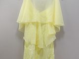 the yellow dress is hanging on a hanger on the wall