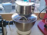 un robot de cuisine rouge posé sur un plan de travail à côté d'un autre robot de cuisine rouge