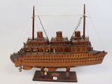 une maquette en bois de bateau posée sur un socle