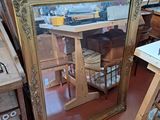 a large mirror sitting on the floor next to a table