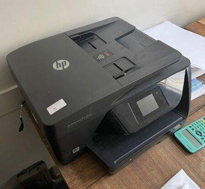 a printer sitting on top of a desk next to a calculator