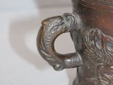 a metal cup with a handle on a white table