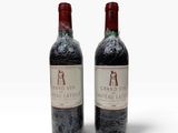 deux bouteilles de vin rouge posées l'une à côté de l'autre sur une surface blanche