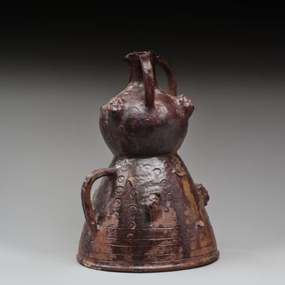 un vieux vase marron surmonté d'un oiseau