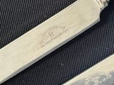 two knives and a spoon on a table