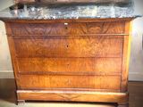 une commode en bois avec un plateau en marbre dans une chambre