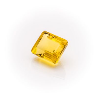 a yellow sapphire stone on a white background