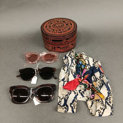 un chapeau, des lunettes de soleil, une écharpe et d'autres objets posés sur une table
