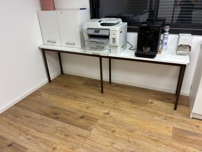 un bureau sur lequel se trouvent une imprimante et une cafetière