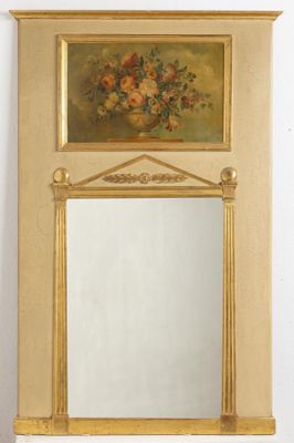 a mirror on the wall with a vase of flowers on it