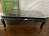 a table with a glass top sitting on a wooden floor