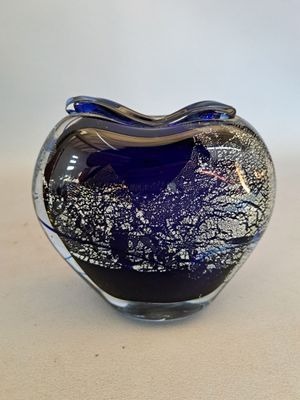 a blue glass heart shaped object on a table