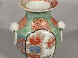 a green vase with a red and white design on it