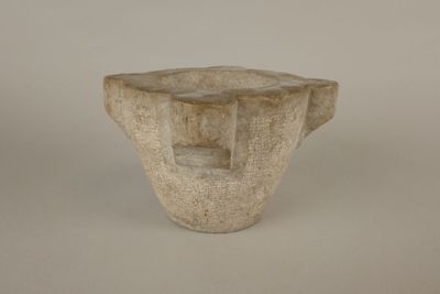 a small stone vase with a square hole in the middle