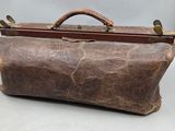 un sac en cuir marron posé sur une surface blanche